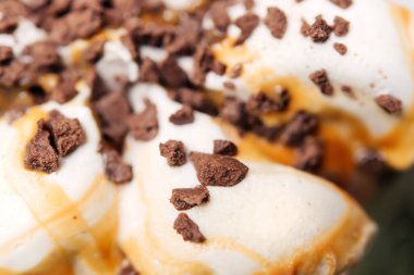 Çikolatalı kurabiyeli vanilyalı dondurma, çikolatalı cips ve karamel, çilekli ya da ahududu soslu.