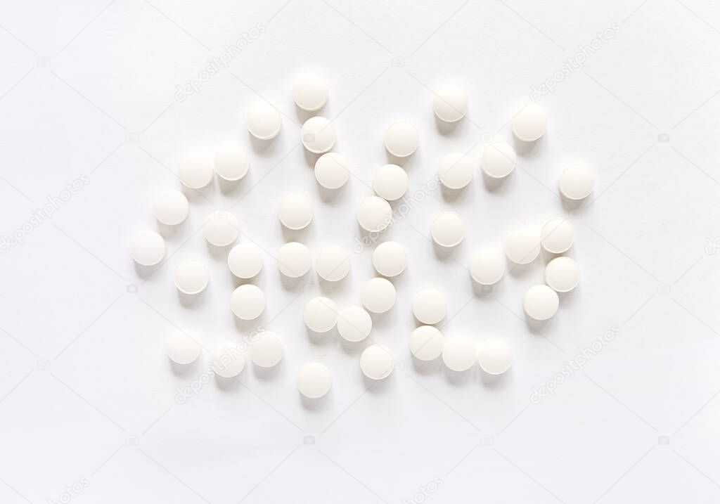White pills on a white background. round pills close-up. Healthcare and medicine.