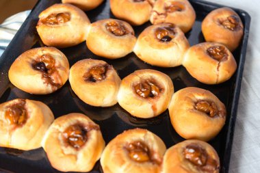 Reçelli ve meyveli maya çöreği pişirme aşamaları. Dördüncü aşama, bitmiş çörekler. Bir dizi fotoğraf. Ev yapımı pişirme..