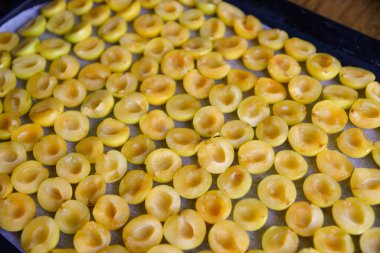 Olgun sarı kiraz eriği, kemiksiz ikiye bölünmüş. Meyve kurutmak ya da dondurmak için hazırlanıyor.