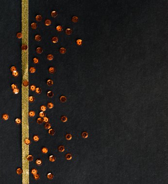 Altın pullu, minimalist dekorlu siyah kağıt arka plan. Zıtlık ve minimalizm kavramı. Kutlama kartpostalı. Gece gökyüzü ve yıldızların simülasyonu.