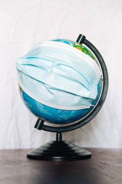 Dünya Salgın Tehlikesi. Dünya 'nın, beyaz bir arka planda, yüz maskesi takarak dünyayı korumaya ihtiyacı var. İnsan Salgını Tehlike. 