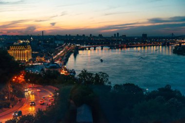 Kiev, Ukrayna - 22 Mayıs 2021. Dinyeper nehrine bakan şehrin akşam manzarası. Gün batımı.