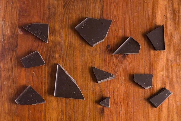 Trozos Rotos Chocolate Negro Sobre Fondo Marrón Madera — Foto de Stock