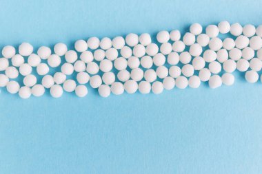 Homeopati ilacı alternatif bitkiler. Mavi arka planda homeopatik küreseller. Sağlık ve Tıp Konsepti.
