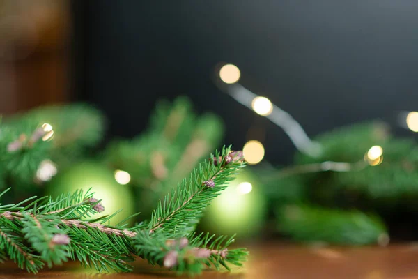 クリスマスの背景 緑の松の枝お祝いの背景 境界線とコピースペースと創造的な組成 電球からのボケライトと新年の装飾 — ストック写真