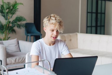 Genç kız dizüstü bilgisayarda çalışıyor. Ev ödevi. Uzak okul.