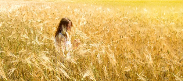 Ukrayna. Olgun altın buğday tarlasında bir kadın.