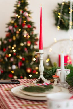 Noel şenlikli yemek masası, içinde mumlar ve yeşil masa seti.