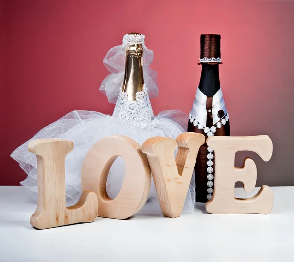 Botellas de recuerdo para una boda en un fondo rojo.La palabra amor — Foto de Stock