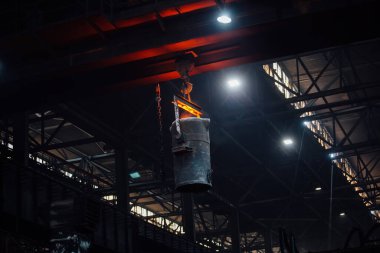 Dökümhanede demir döküm. Metalurji fabrikasında erimiş metalle dolu kepçeli vinç..