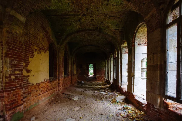 Dark corridor of old ancient abandoned red brick ruined historical building