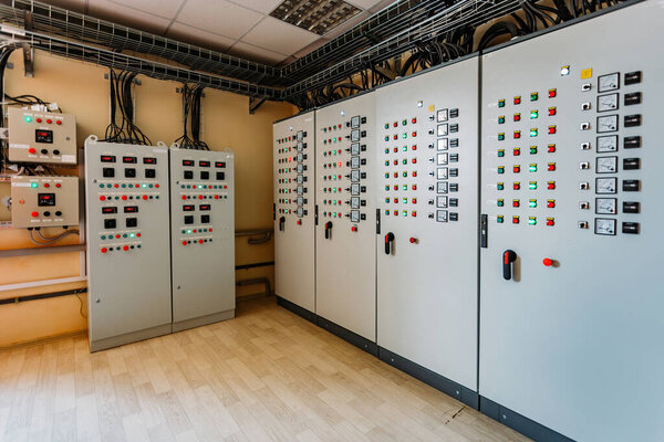 Electrical switchgear cabinets with control panels with indicator lights in factory.