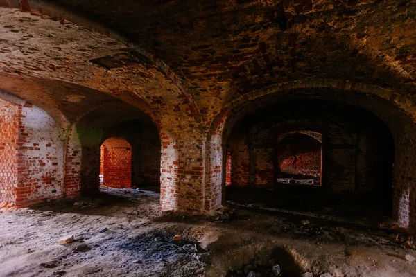 Dark and creepy vaulted red brick dungeon.