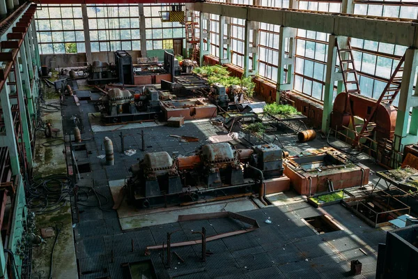 Eski terk edilmiş fabrika, atölyesinde paslı endüstriyel makineler var..