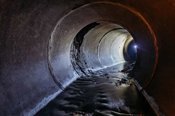 Översvämmad rund avloppstunnel med vattenreflektion — Stockfoto