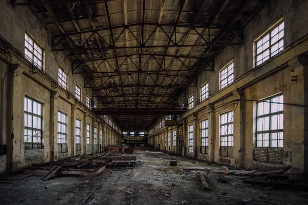 Abandoned factory. Large empty industrial hall with garbage.