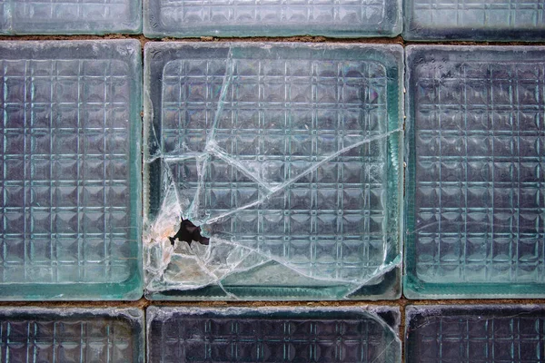 Old broken glass block window, close up view.