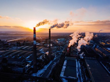 Günbatımında sanayi manzarası, hava manzarası. Fabrika bacalarından duman çıkıyor..