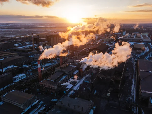 Industrial landscape at the sunset, aerial view. Smoke coming out from factory chimneys.