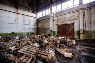 Yıkımı bekleyen çöplerle dolu büyük sanayi salonunu terk ettim..