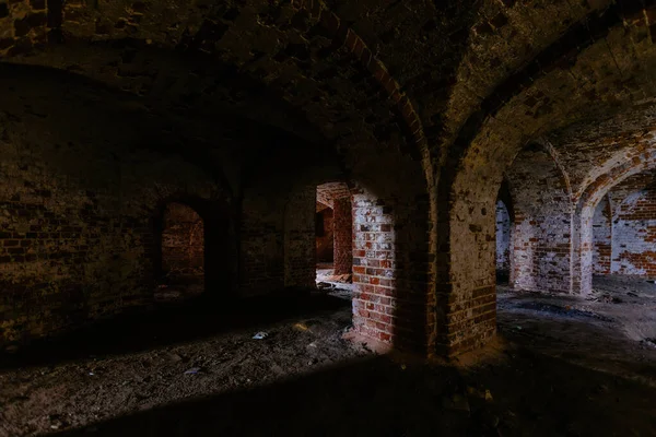 Dark and creepy vaulted red brick dungeon.