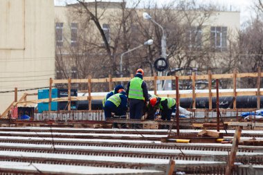 Workers in protective helmets are repairing bridge in Voronezh.