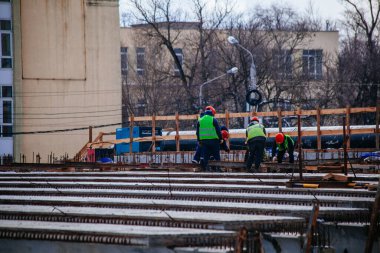 Workers in protective helmets are repairing bridge in Voronezh.