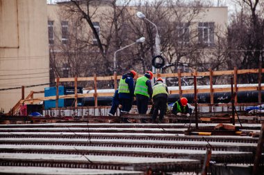 Workers in protective helmets are repairing bridge in Voronezh.