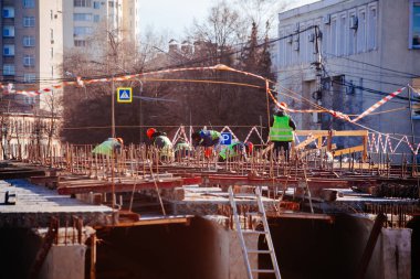 Workers in protective helmets are repairing bridge in Voronezh.