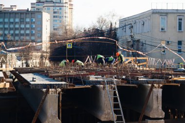 Workers in protective helmets are repairing bridge in Voronezh.