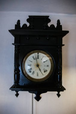 Antique old vintage clock on white wall.