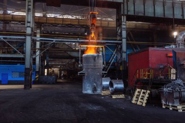 Demir döküm ve dökümhane. Metalurji fabrikasında erimiş metalle dolu kepçeli vinç..