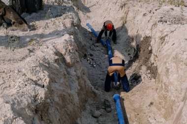 İşçiler su tedarik boru hattı sistemi kuruyor.