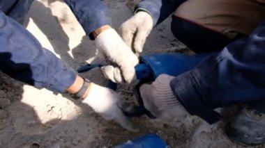 İşçi boru hattı kurulumu için boruya kelepçe takıyor