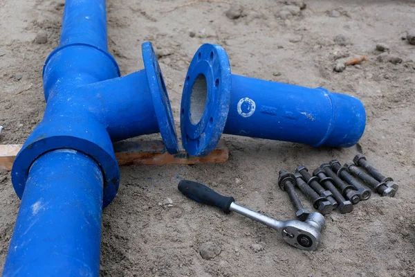 Cast metal pipe connection with flange and tools.