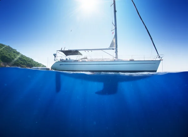 Erstaunliches Sonnenlicht Meerblick auf Segelboot in tropischem Meer mit tiefblauem Untergrund durch Wasserlinie gespalten — Stockfoto