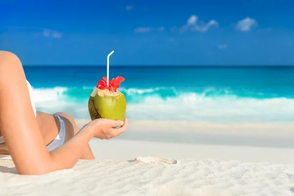 Jonge vrouw in zwembroek met kokos cocktail op het strand, Seychellen — Stockfoto