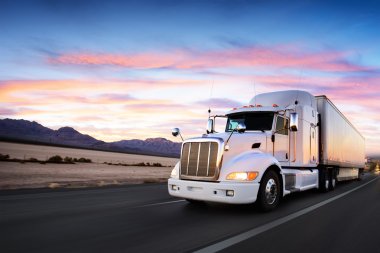 Truck and highway at sunset - transportation background clipart