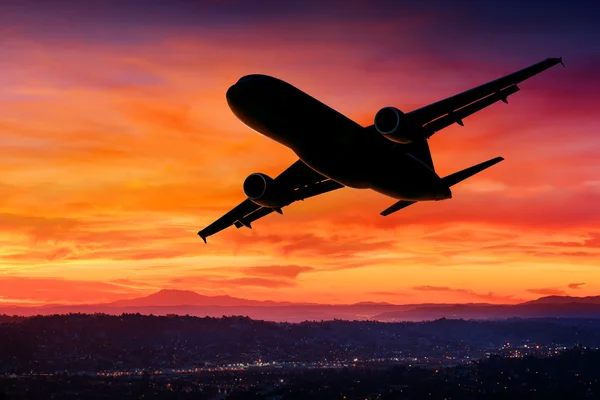 Silhouette d'avion dans le ciel au coucher du soleil Photos De Stock Libres De Droits