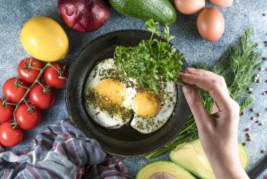 Biberli yumurta ve gri arka planda kekik, taze domates.