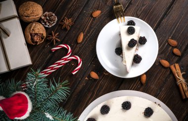 Ahşap bir masada böğürtlenli yılbaşı pastası..