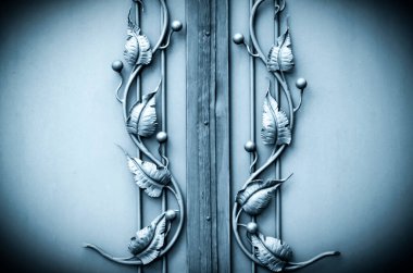 İşlenmiş demirden çitlerin üzerindeki çiçek süsü.