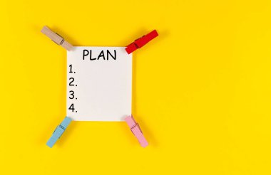 Sarı arkaplanda renkli askılar ve beyaz çarşaf