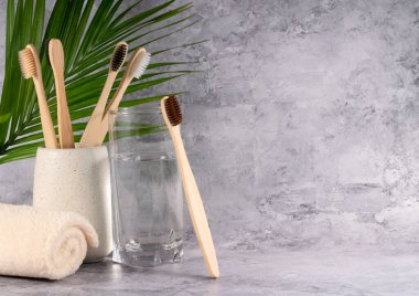 Gri arka planda bir bardakta eko diş fırçaları