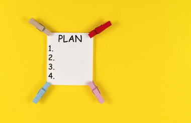 Sarı arkaplanda renkli askılar ve beyaz çarşaf