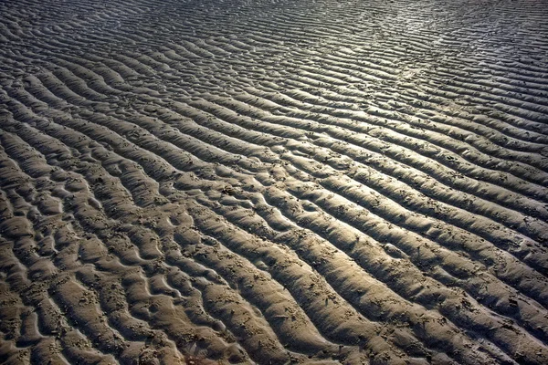 Wellen am Sandstrand Stockfoto