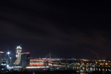 Geceleri Belgrad 'da panoramik manzara, Sava Nehri' nde rekabet ve üzerine köprüler ve limana yönelik yepyeni binalar