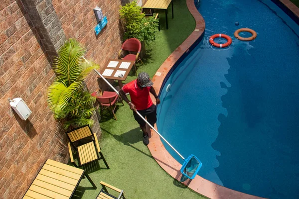 Profesyonel işçi - havuz temizleyicisi havuzu temiz-ağ ile temizler, tropik bir yerdeki özel konutta
