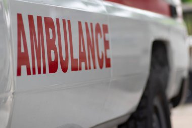 Acil tıbbi yardım için ambulans aracını kapatın. Görünür kırmızı haç, acil durum ışıkları ve siren.